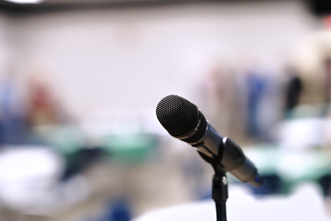 Close up of a professional camera filming a speaker at a podium